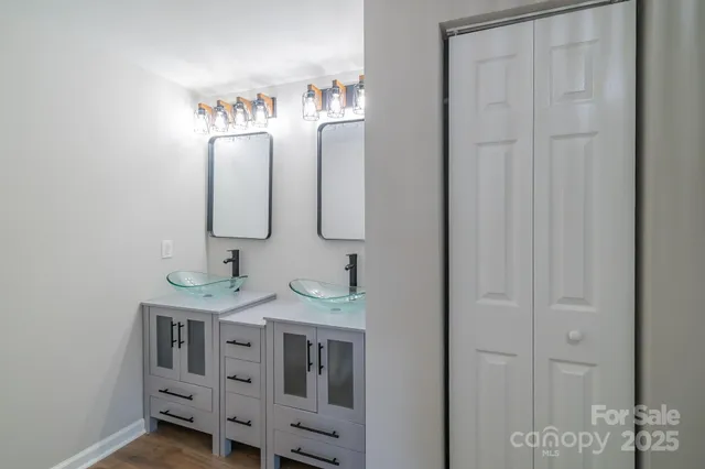 a bathroom with double vanity sink and a mirror