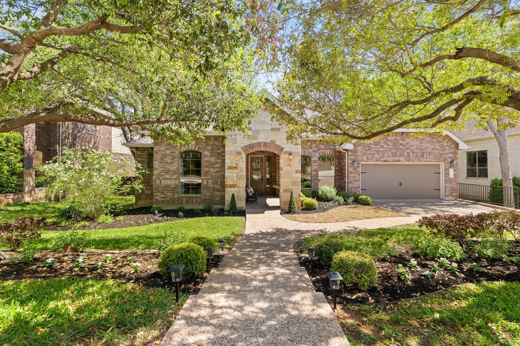 Welcome home to a stunning first impression, where towering mature trees and manicured landscaping frame your private retreat