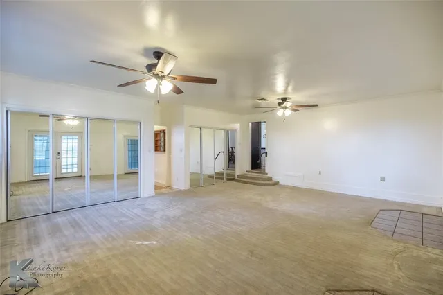a view of an empty room with a ceiling fan