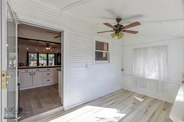 a view of a hallway with chandelier fan and windows