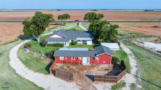 an aerial view of a house with a yard and lake view