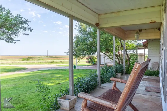 a view of a patio with lawn chairs floor to ceiling window and wooden floor