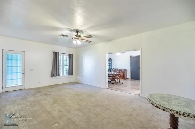 an empty room with furniture and fan
