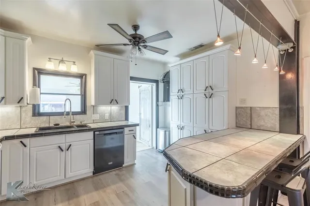 a kitchen with a stove a sink a refrigerator and cabinets
