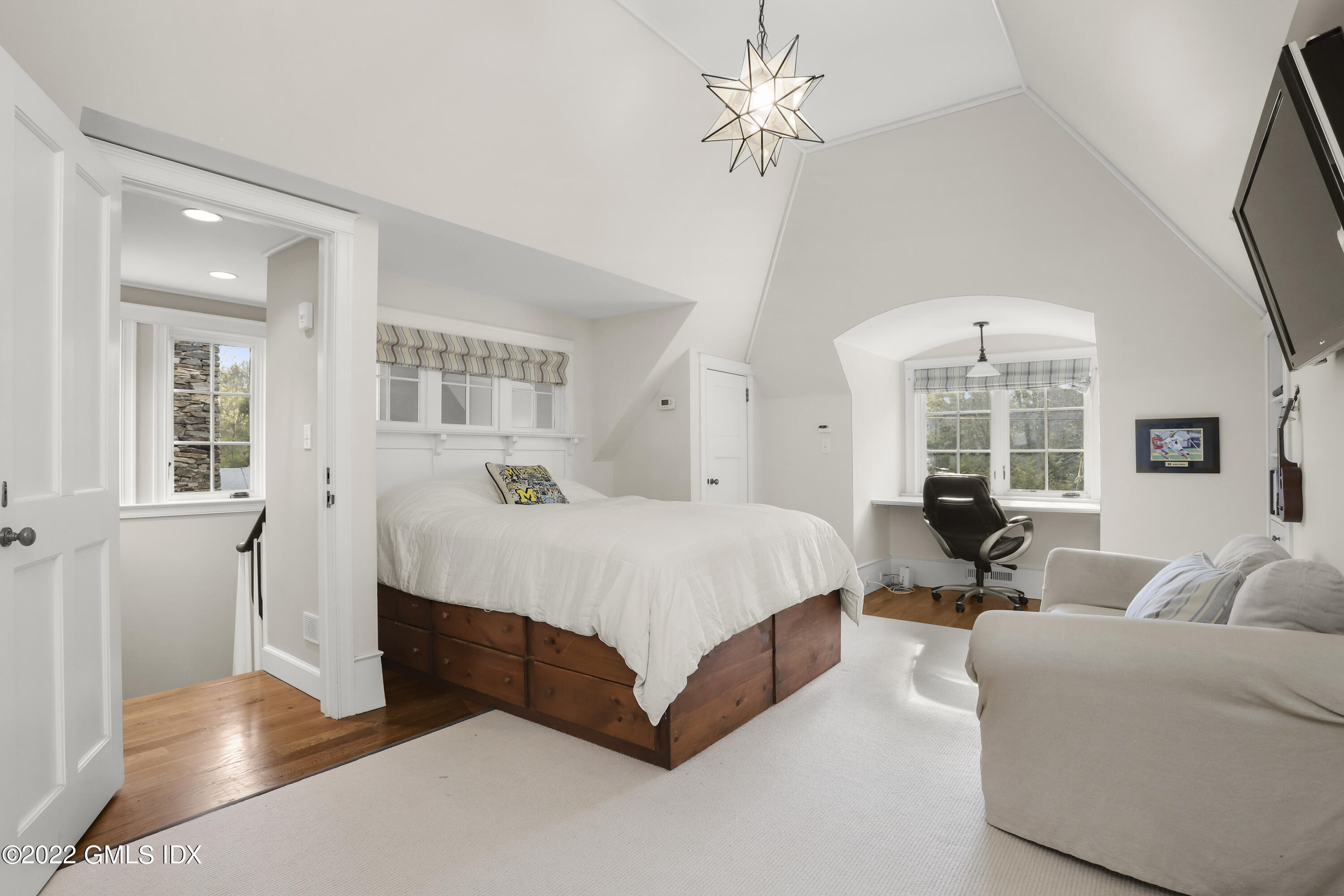 22 Glen Road Greenwich, CT 06830 - Photo 23 of 30 a spacious bedroom with a large bed and a chandelier