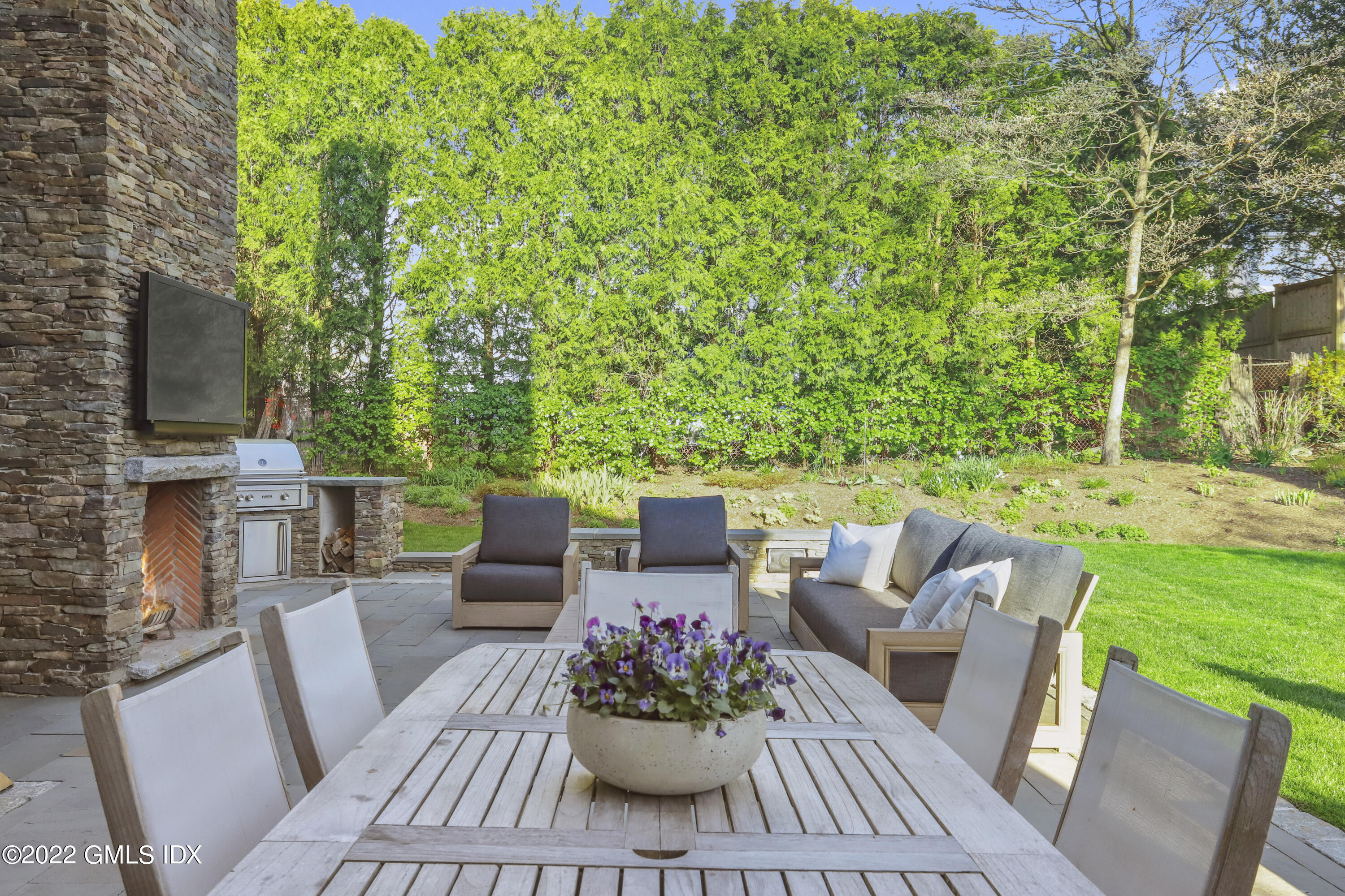 22 Glen Road Greenwich, CT 06830 - Photo 5 of 30 a view of a patio with a table and chairs potted plants with large tree