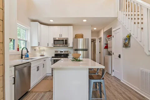 a kitchen with refrigerator cabinets and wooden floor