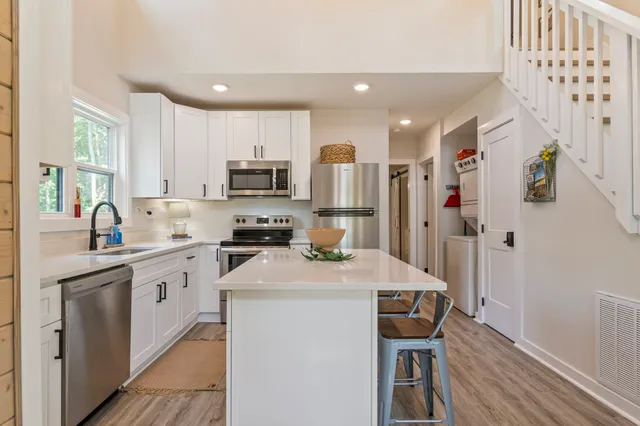 a kitchen with refrigerator cabinets and wooden floor