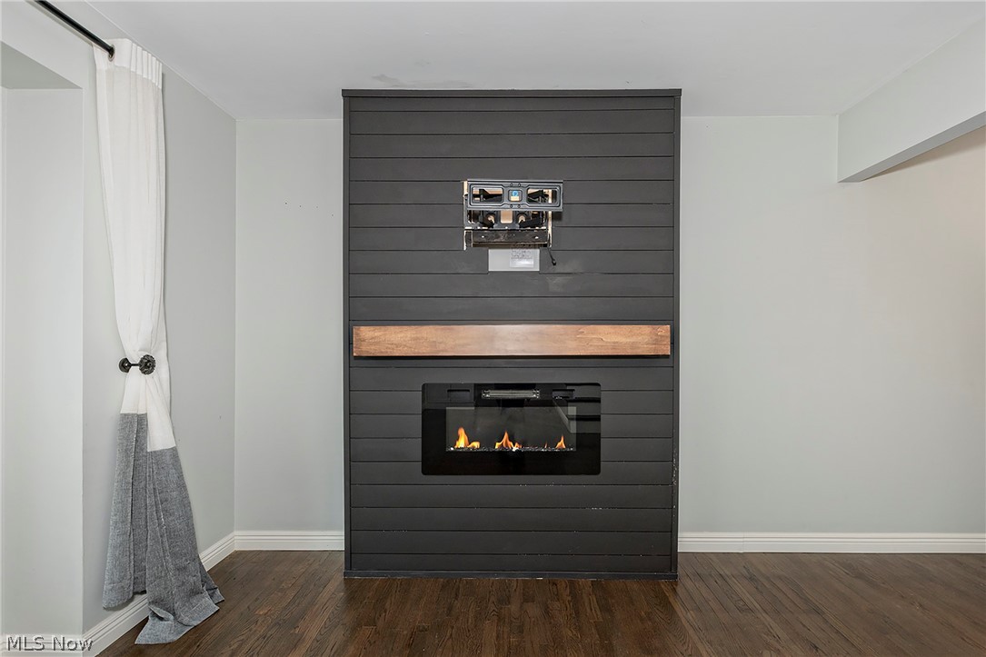 3719 Walter Road North Olmsted, OH 44070 - Photo 6 of 35 Modern black shiplap fireplace with a wood-finish mantel and integrated electric insert