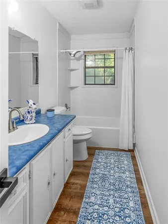 a bathroom with a sink a toilet a mirror and shower