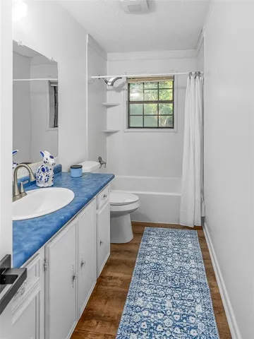 a bathroom with a sink a toilet a mirror and shower