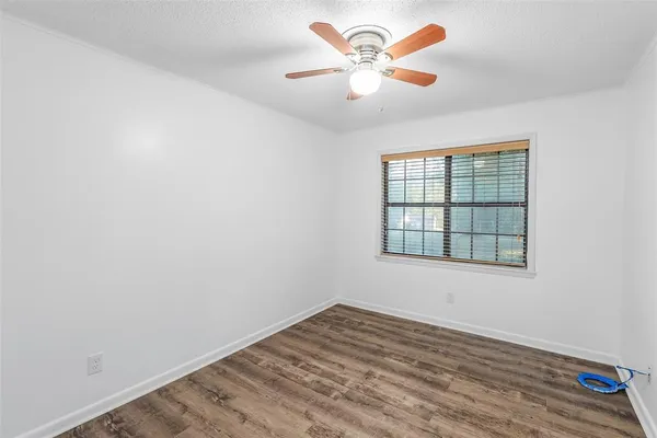 an empty room with a window and a fan