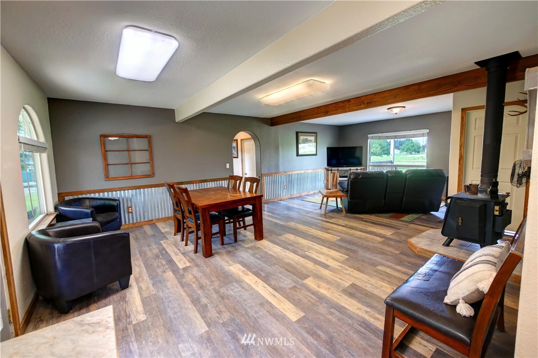 7 Woods Road Omak, WA 98841 - Photo 14 of 39 a living room with furniture a dining table and a flat screen tv with wooden floor