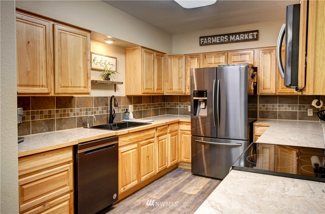 7 Woods Road Omak, WA 98841 - Photo 9 of 39 a kitchen with stainless steel appliances granite countertop a refrigerator sink and cabinets