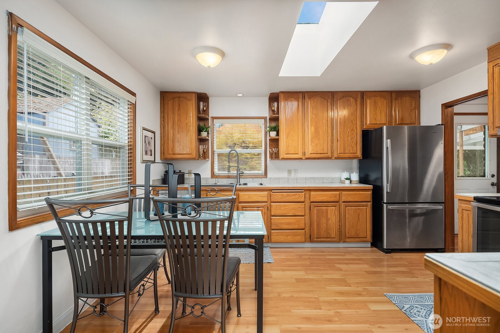 15013 Southeast 113th Street Renton, WA 98059 - Photo 6 of 26 a kitchen with stainless steel appliances granite countertop a stove a refrigerator a kitchen island and chairs in it