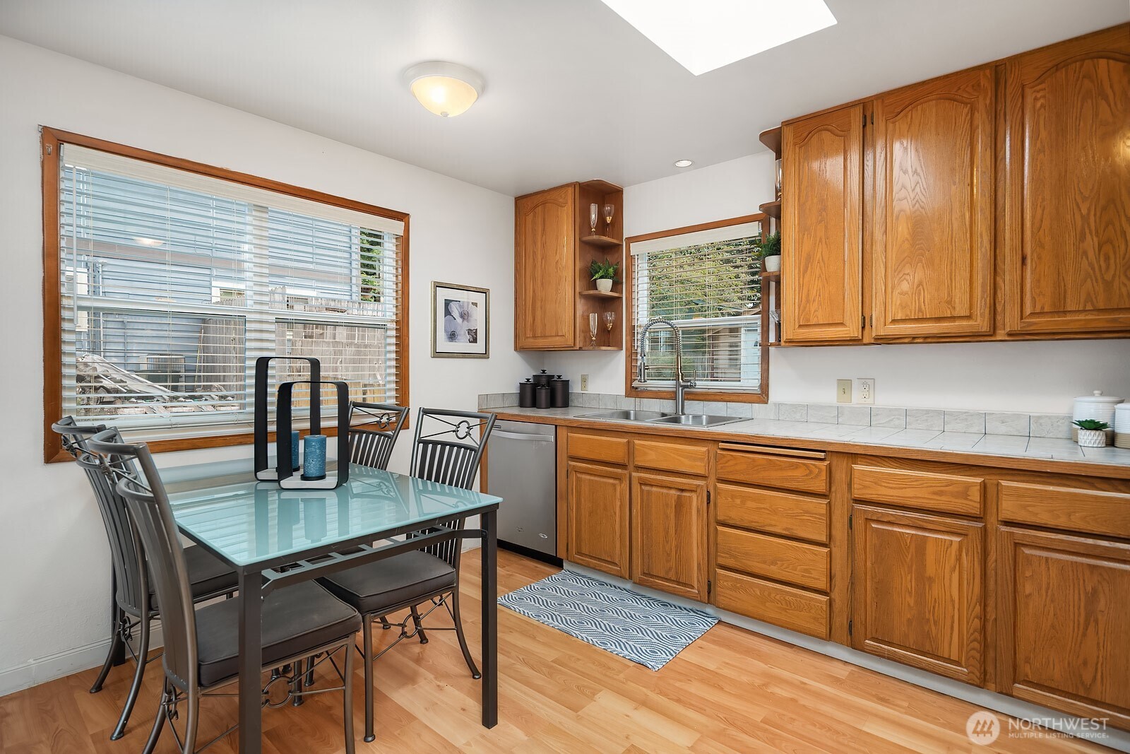15013 Southeast 113th Street Renton, WA 98059 - Photo 7 of 26 a kitchen with granite countertop wooden cabinets dining table and chairs