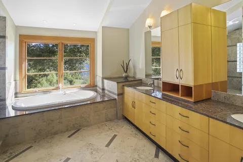 a spacious bathroom with a granite countertop tub sink and mirror