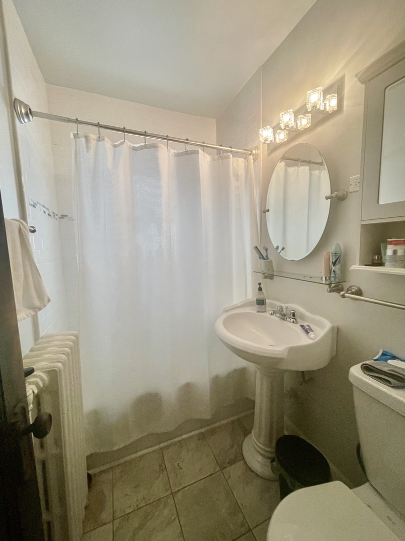 1112 Grove Street, Unit 1B Evanston, IL 60201 - Photo 13 of 14 a bathroom with a sink toilet and a mirror