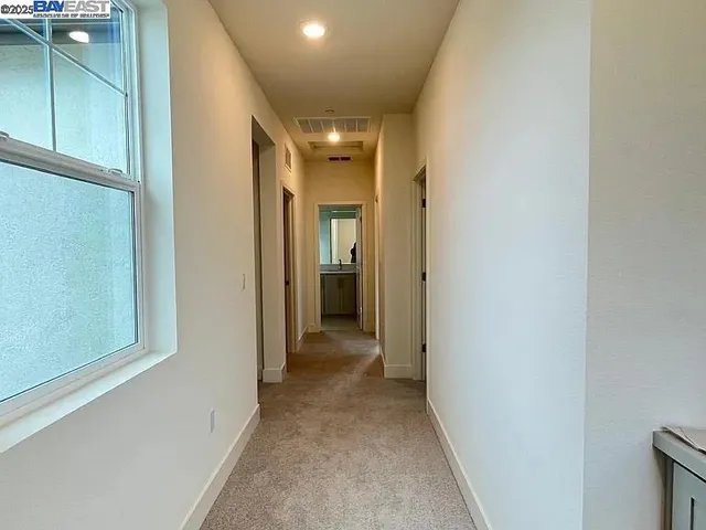 a view of a hallway with wooden shelves
