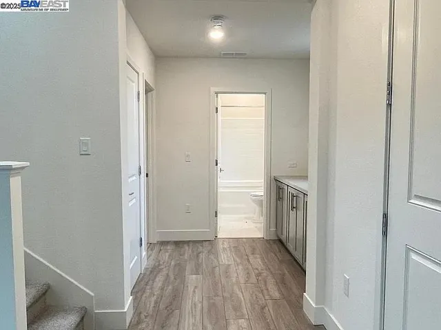 a view of a hallway with wooden floor