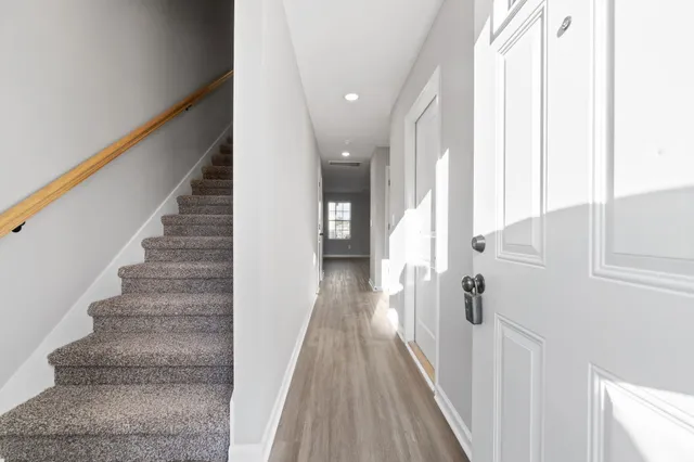 a view of a hallway with wooden floor and staircase