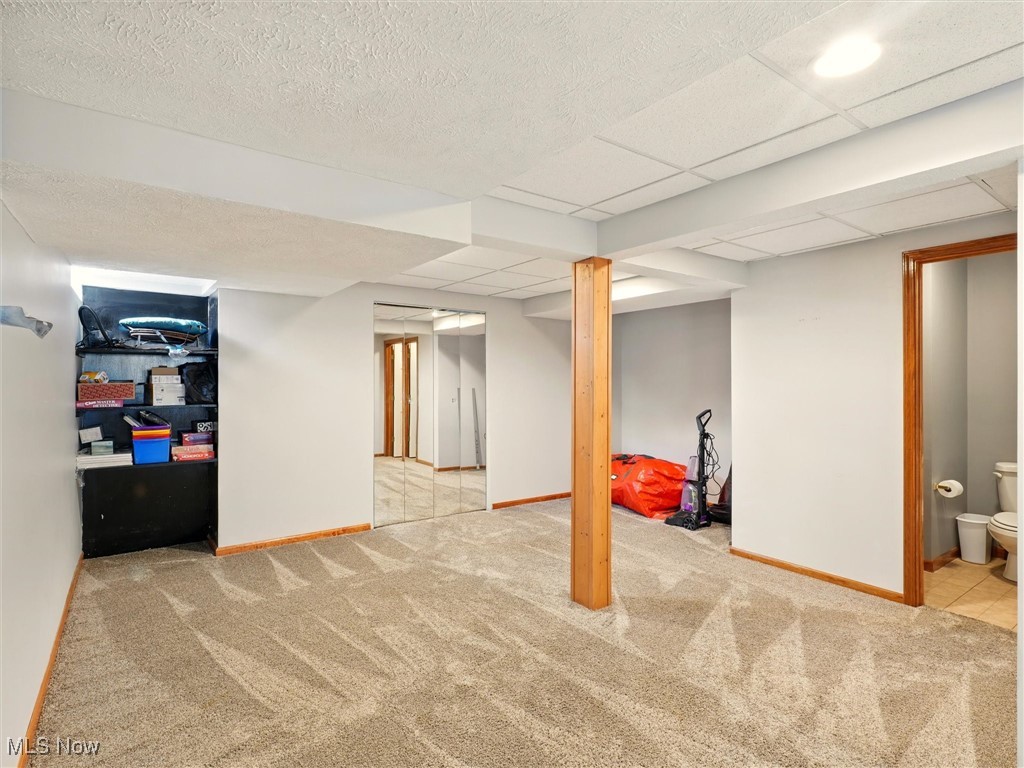 2068 Chimney Ridge Drive Madison, OH 44057 - Photo 29 of 37 Finished basement with baseboards, a drop ceiling, and carpet floors