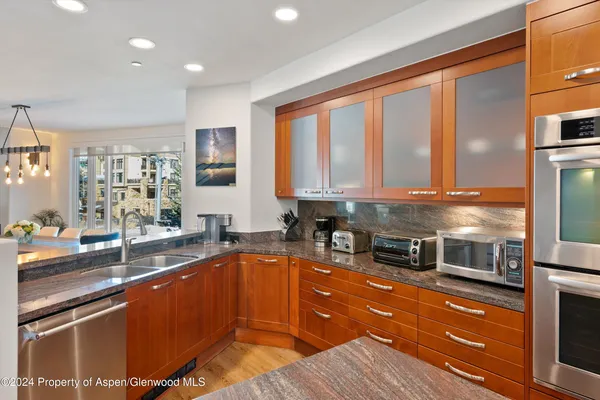 a kitchen with stainless steel appliances granite countertop a sink stove and cabinets