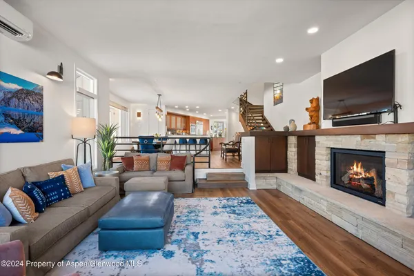 a living room with furniture a flat screen tv and a fireplace