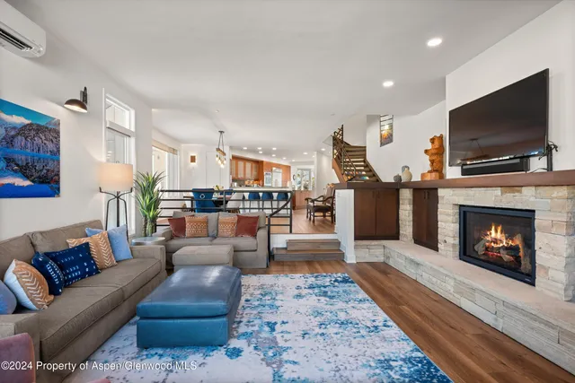 a living room with furniture a flat screen tv and a fireplace