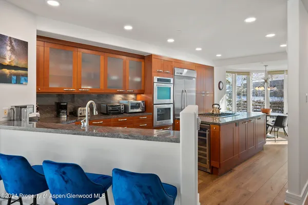 a kitchen with stainless steel appliances granite countertop sink stove and wooden cabinets