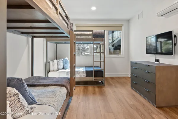 a bedroom with a large bed and a flat tv screen on dresser