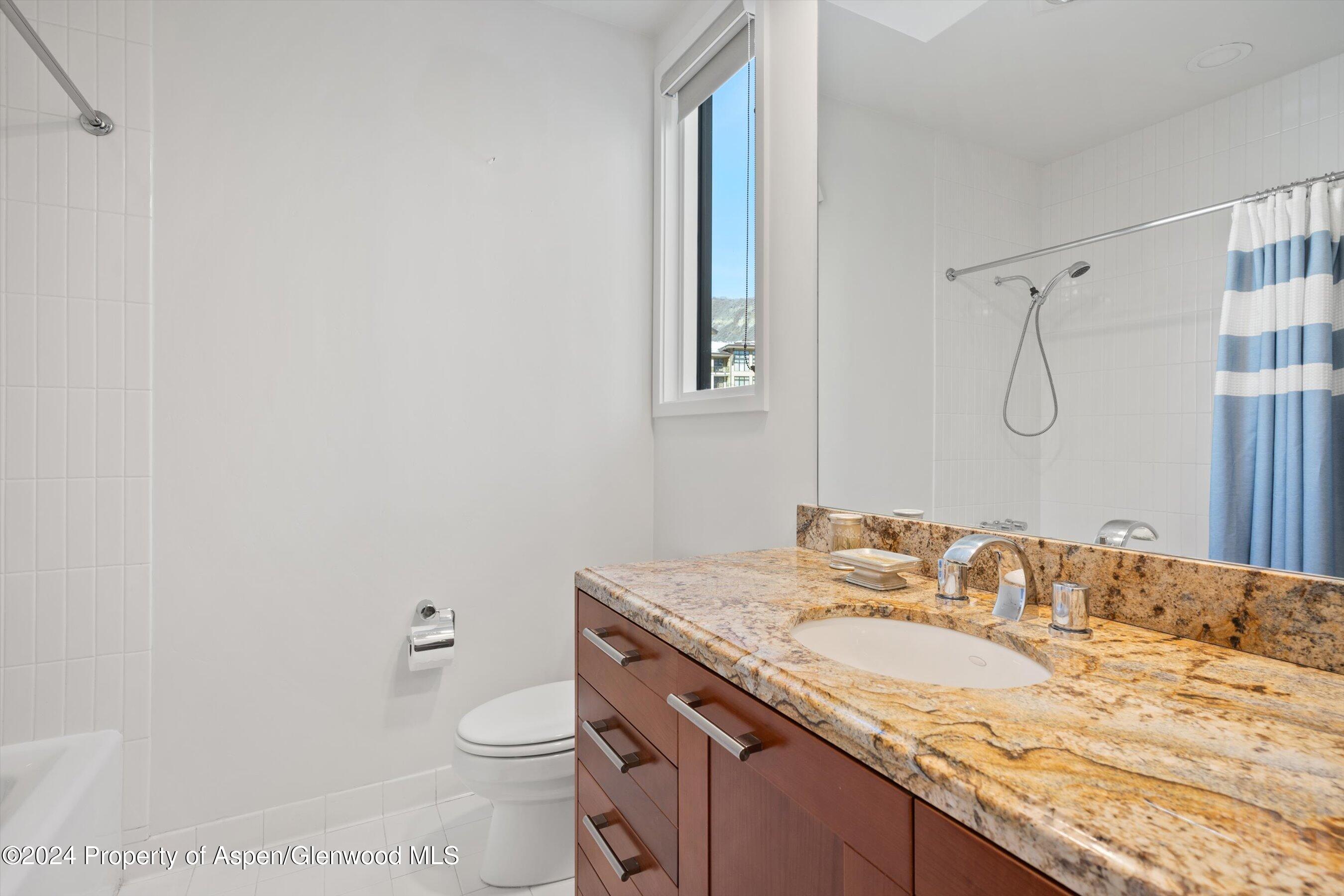 381 Ridge Road, Unit A5 Snowmass Village, CO 81615 - Photo 23 of 43 a bathroom with a granite countertop sink a toilet and a mirror