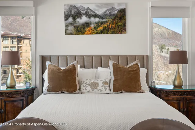 a large bed sitting in a bedroom next to a window