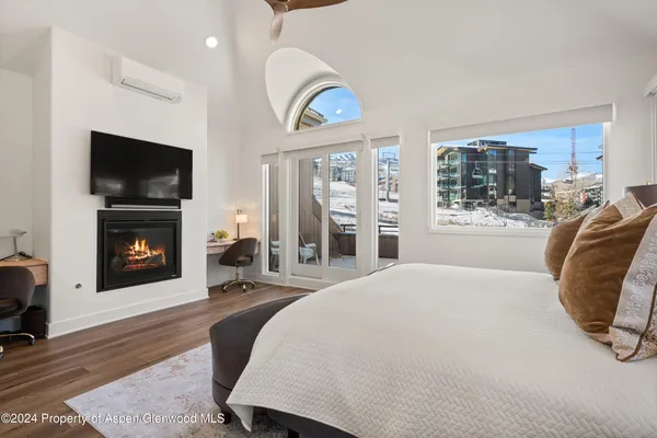 a spacious bedroom with a bed and a flat screen tv