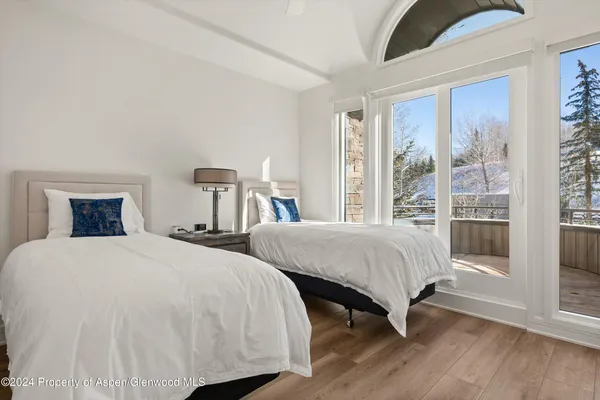 a bedroom with two beds and a large window