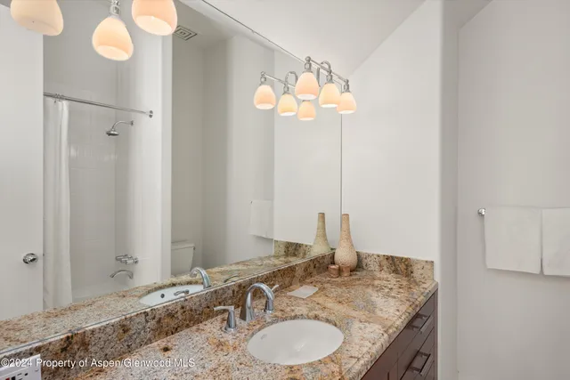 a bathroom with a granite countertop sink and a mirror