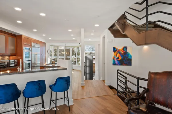 a kitchen with stainless steel appliances granite countertop a refrigerator and a dining table