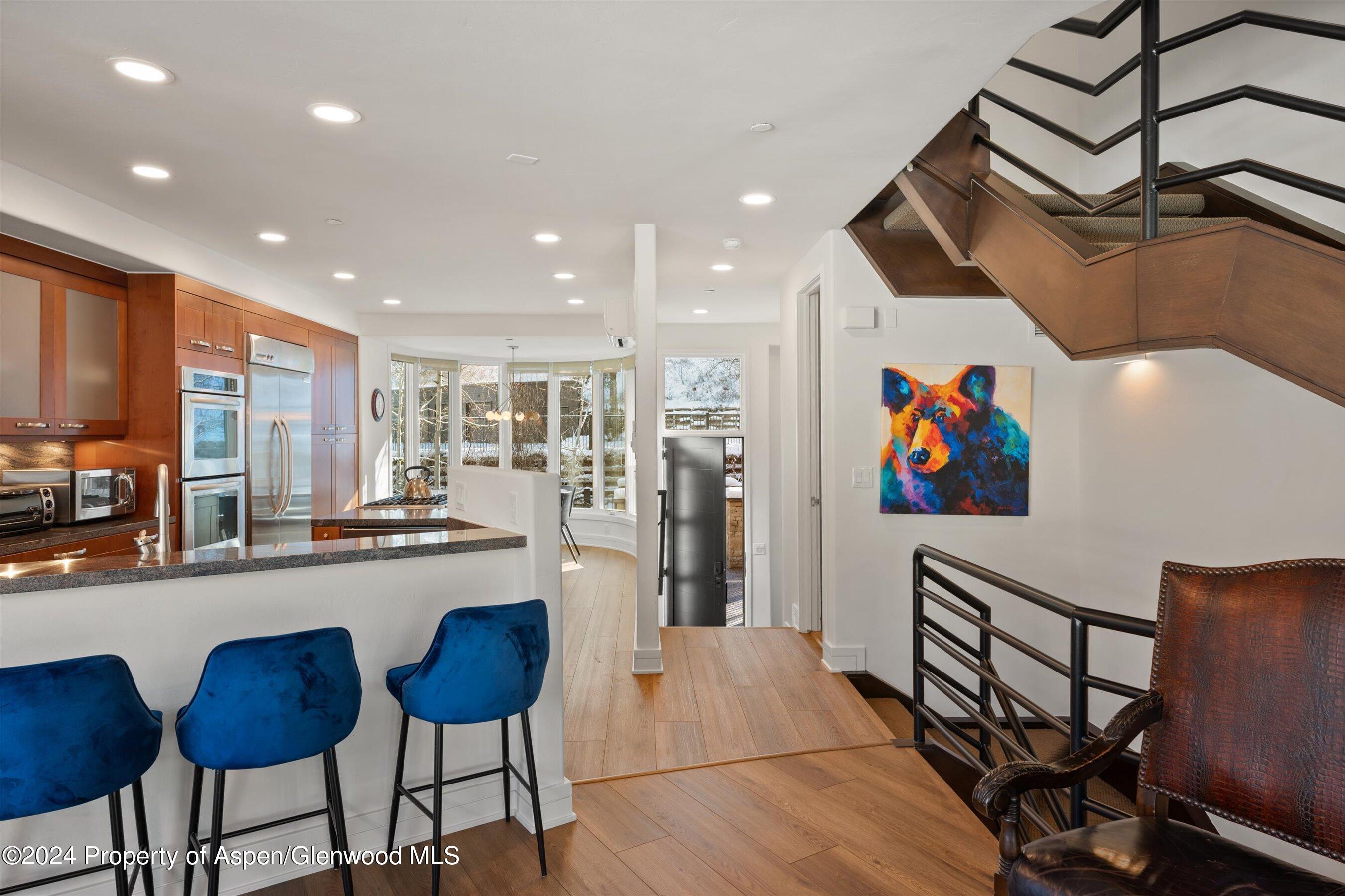 381 Ridge Road, Unit A5 Snowmass Village, CO 81615 - Photo 4 of 43 a kitchen with stainless steel appliances granite countertop a refrigerator and a dining table