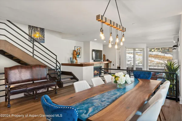 a view of a dining room with furniture a rug and wooden floor