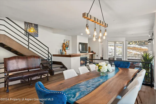 a view of a dining room with furniture a rug and wooden floor