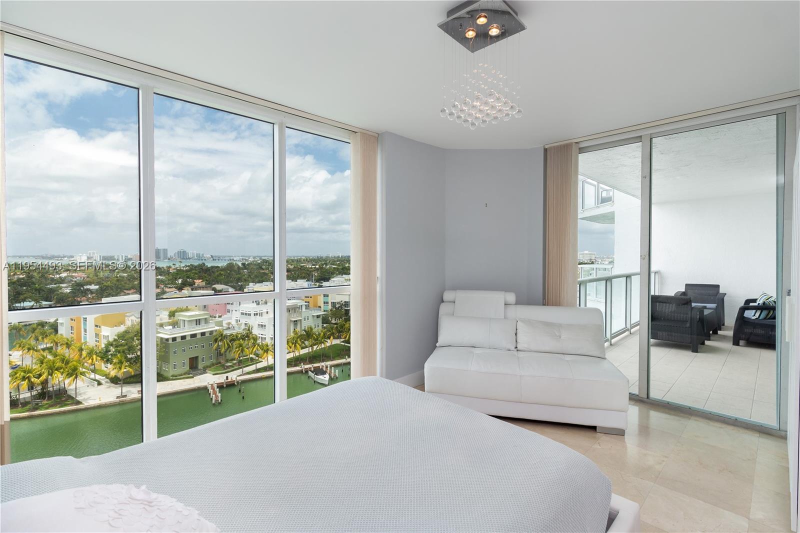 5900 Collins Avenue, Unit 1207 Miami Beach, FL 33140 - Photo 1 of 25 a living room with furniture and a floor to ceiling window