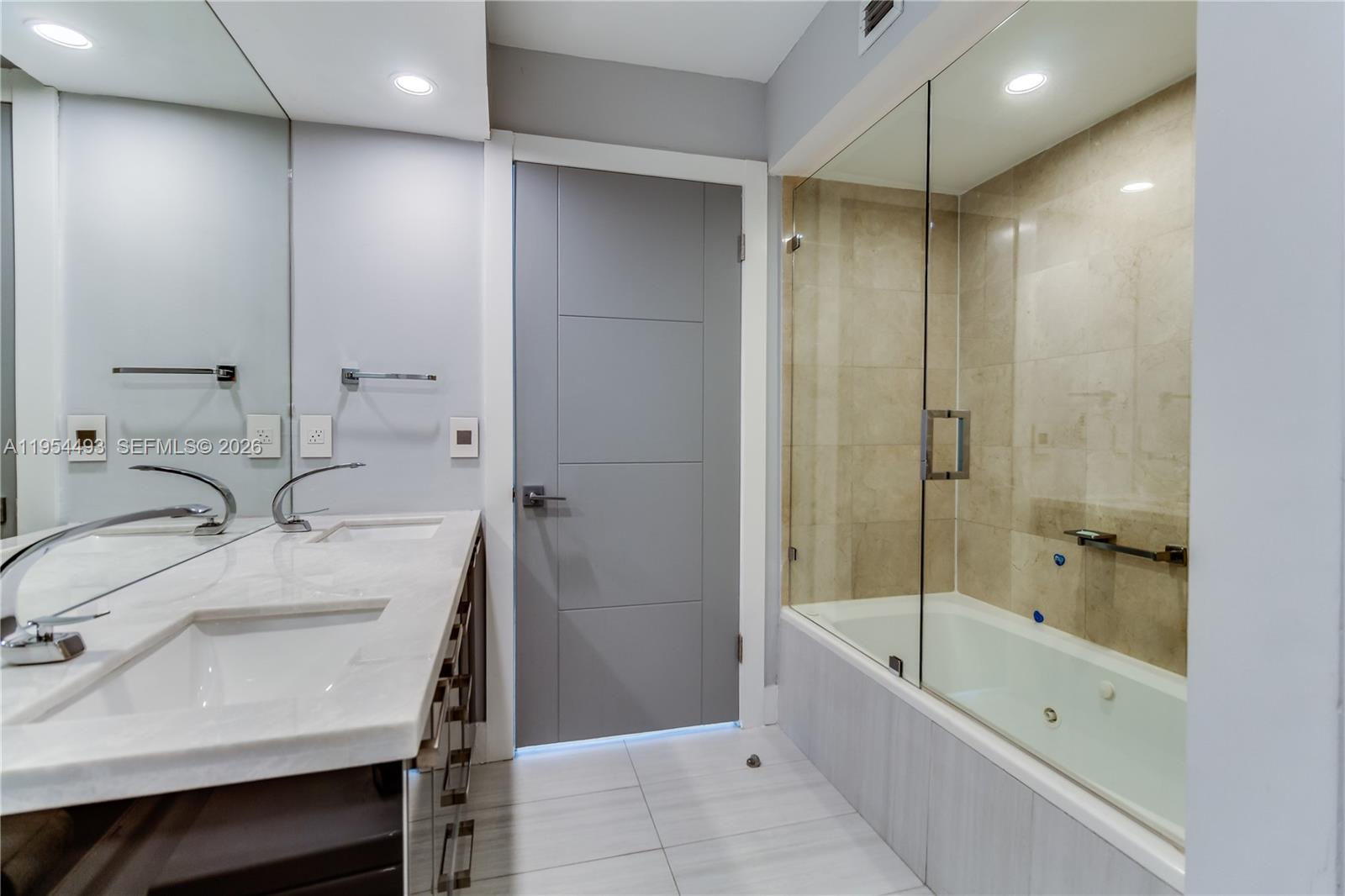 5900 Collins Avenue, Unit 1207 Miami Beach, FL 33140 - Photo 16 of 25 a bathroom with a bathtub shower sink and mirror