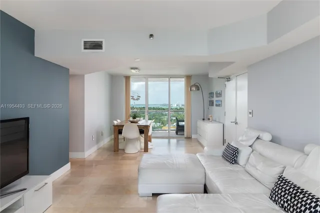 a living room with furniture a flat screen tv and a large window