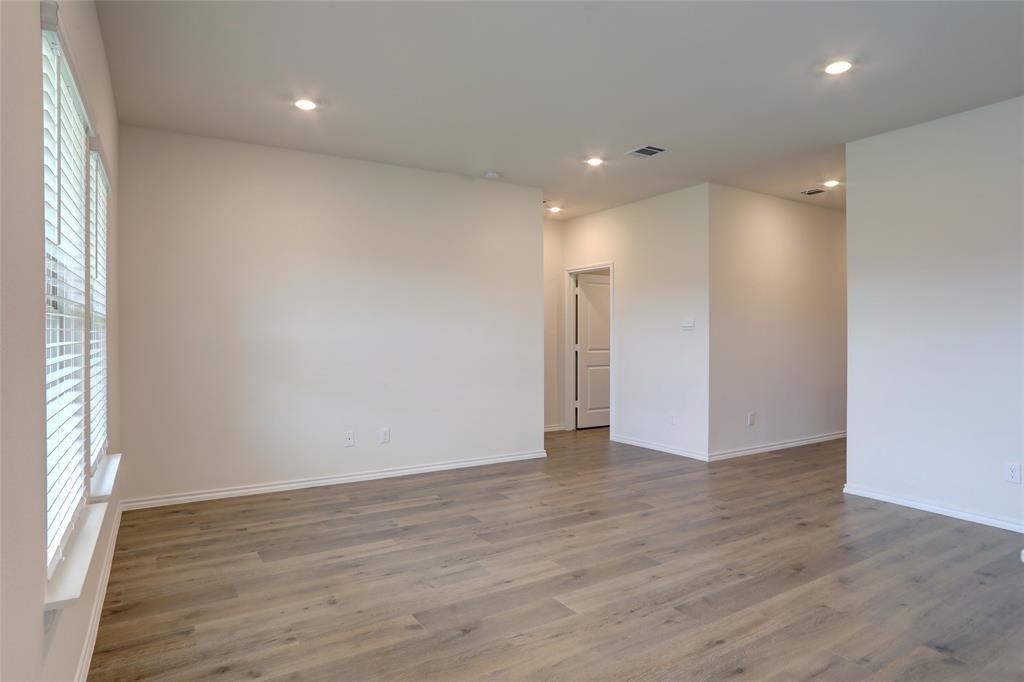 6517 Waterfall Lane Princeton, TX 75407 - Photo 10 of 19 an empty room with wooden floor and windows