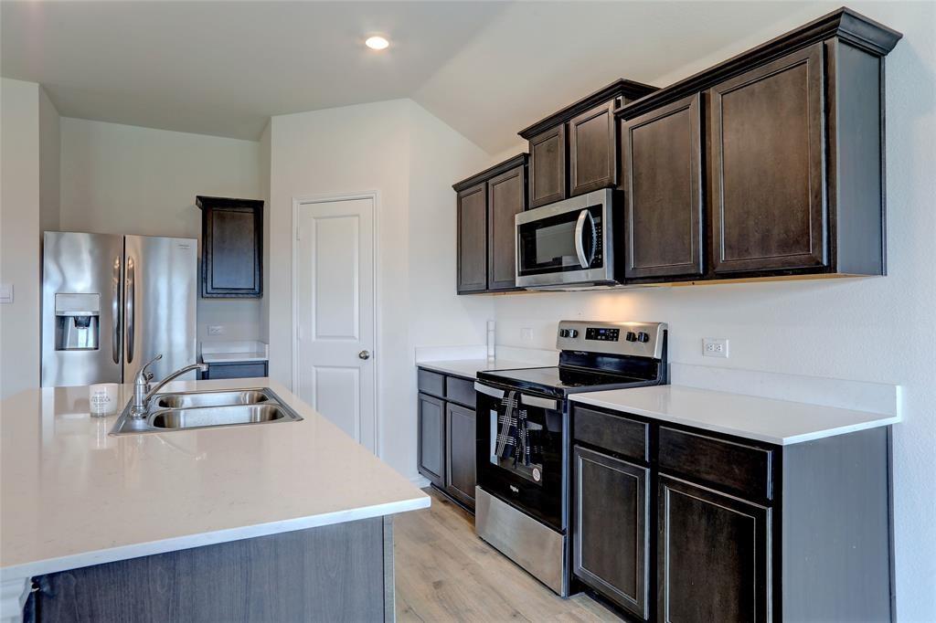 6517 Waterfall Lane Princeton, TX 75407 - Photo 4 of 19 a kitchen with kitchen island a counter top space cabinets and stainless steel appliances