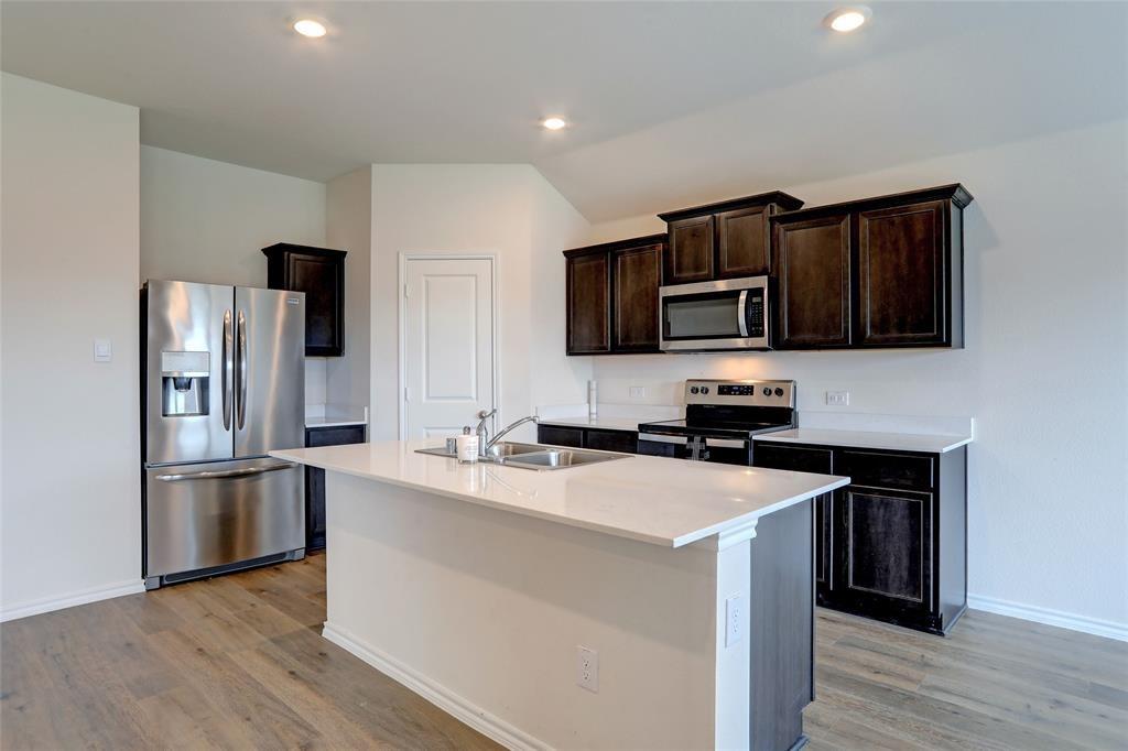 6517 Waterfall Lane Princeton, TX 75407 - Photo 6 of 19 a kitchen with stainless steel appliances a microwave sink refrigerator and cabinets