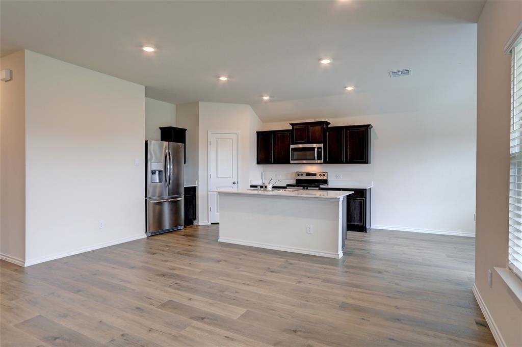 6517 Waterfall Lane Princeton, TX 75407 - Photo 7 of 19 a view of kitchen with microwave refrigerator and white cabinets