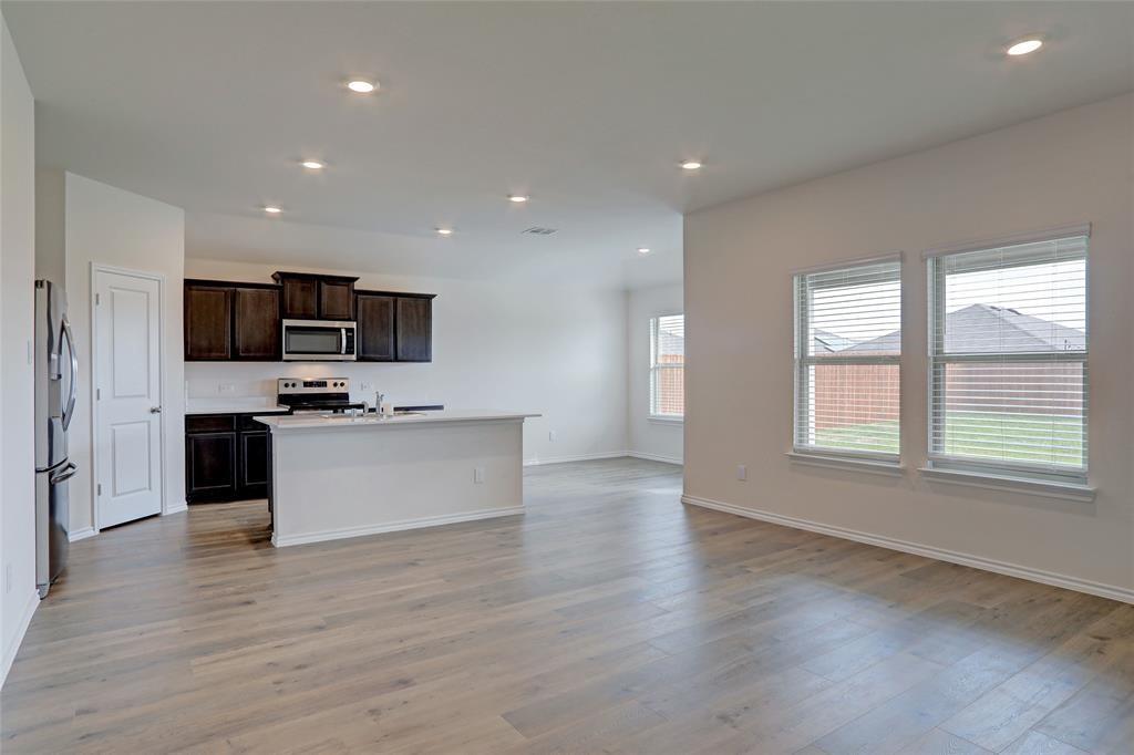 6517 Waterfall Lane Princeton, TX 75407 - Photo 19 of 19 a view of kitchen with microwave a stove and wooden floor