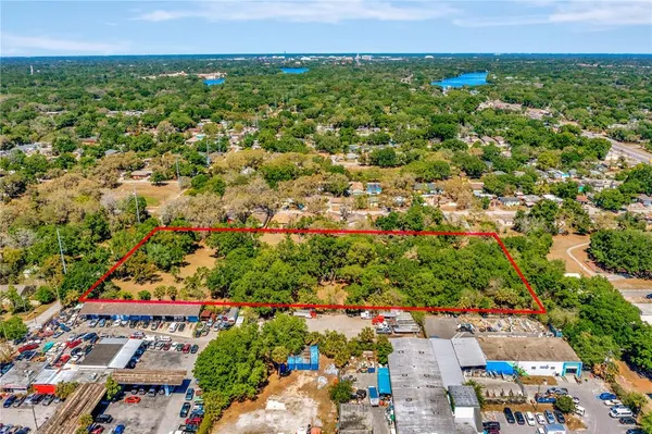 an aerial view of residential houses with outdoor space and trees