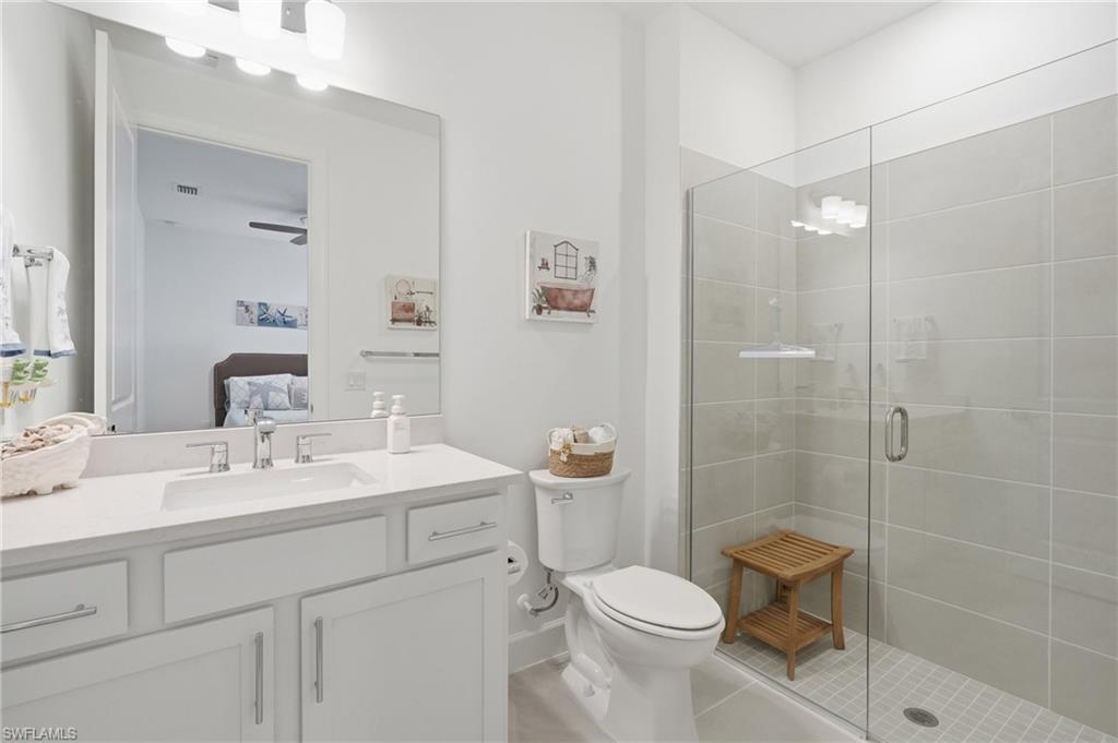 18364 Ridgeline Drive Estero, FL 33928 - Photo 27 of 50 a bathroom with a sink toilet a mirror and shower